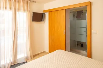a bedroom with a bed and a window and a television at Villa Arianna in Kalathos