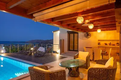 a villa with a swimming pool and a table and chairs at Villa Arianna in Kalathos
