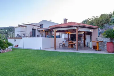 a house with a patio and a grass yard at Villa Arianna in Kalathos