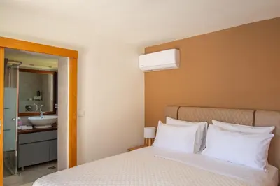 a bedroom with a bed and a bathroom with a sink at Villa Arianna in Kalathos