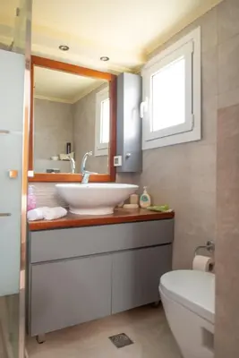 a bathroom with a sink and a toilet and a mirror at Villa Arianna in Kalathos