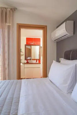 a bedroom with a white bed and a view of a kitchen at Villa Arianna in Kalathos