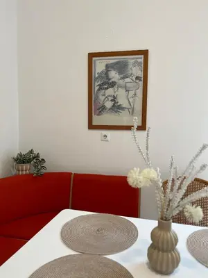 a dining room table with a red couch and a vase at Andri's Garden House in Psinthos