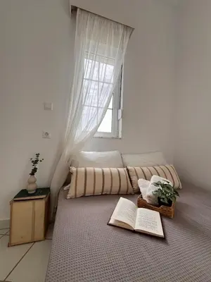 a bedroom with a bed with two books on the floor at Andri's Garden House in Psinthos