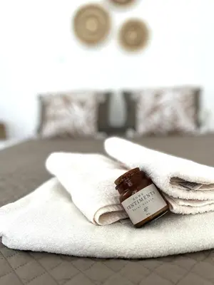 a bottle of honey sitting on a pile of towels at Andri's Garden House in Psinthos