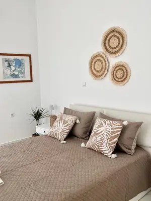 a bedroom with a bed with pillows on it at Andri's Garden House in Psinthos