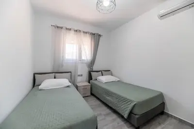 two beds in a small room with a window at Pelagos in Vrachonisída touArchangélou