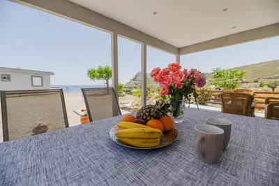 a table with a plate of fruit and flowers on it at Pelagos in Vrachonisída touArchangélou