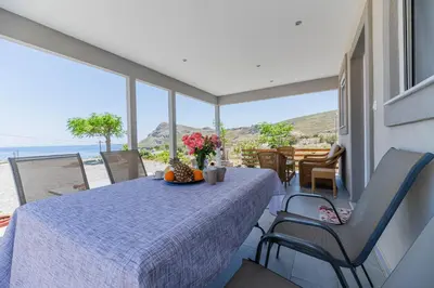 a dining room with a table and a view of the ocean at Pelagos in Vrachonisída touArchangélou
