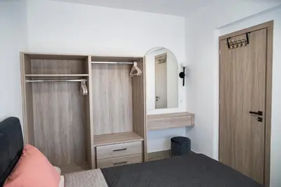 a bedroom with a bed and a mirror and a door at RENI APARTMENT Faliraki in Faliraki