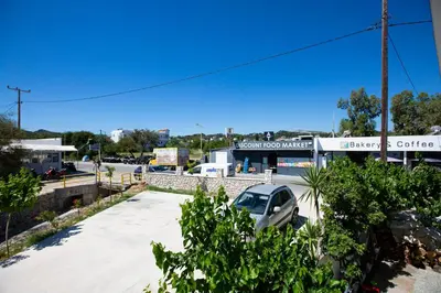 a car parked in a parking lot in front of a coffee shop at RENI APARTMENT Faliraki in Faliraki