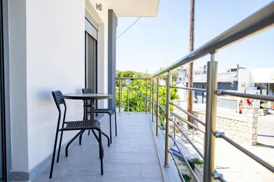 a balcony with two chairs and a table at RENI APARTMENT Faliraki in Faliraki