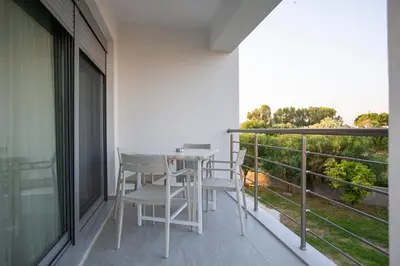 a balcony with a table and chairs on it at RENI APARTMENT Faliraki in Faliraki