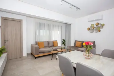 a living room with a table and a couch at RENI APARTMENT Faliraki in Faliraki