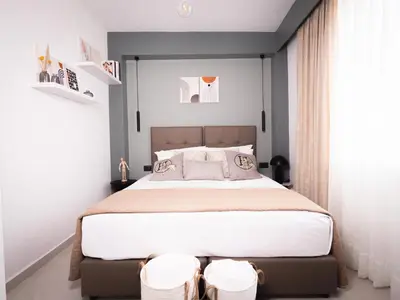 a bedroom with a large bed with two stools at Sea Side Apartment Rhodes City Center in Rhodes Town