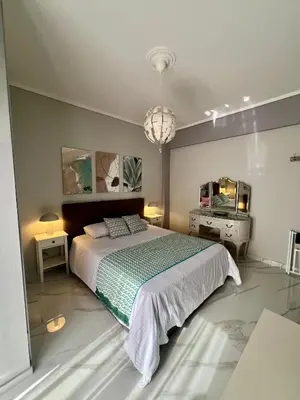 a bedroom with a large bed and a chandelier at Paradise City Apartment 2 in Rhodes Town