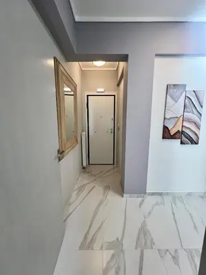 a hallway with white walls and marble floors at Paradise City Apartment 2 in Rhodes Town