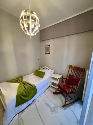 a bedroom with a bed and a chair and a chandelier at Paradise City Apartment 2 in Rhodes Town