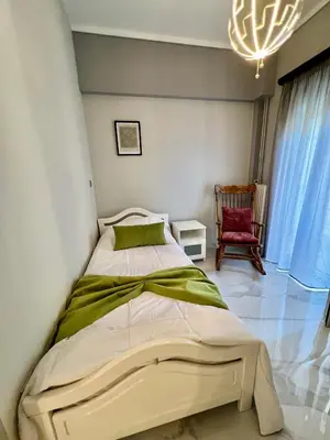a bedroom with a bed with a chandelier and a chair at Paradise City Apartment 2 in Rhodes Town