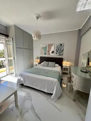 a bedroom with a bed and a dresser and a table at Paradise City Apartment 2 in Rhodes Town