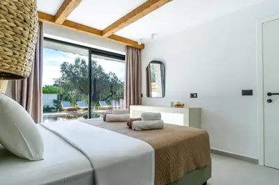 a bedroom with a large bed and a large window at Brillante VIllas by Renthub in Kolimbia