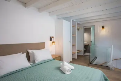 a bedroom with a bed with a teddy bear on it at Nouvelle15 Cozy House with Private Pool in Koskinou