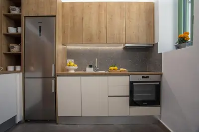 a kitchen with white cabinets and a stainless steel refrigerator at Nouvelle15 Cozy House with Private Pool in Koskinou