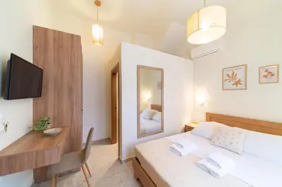 a bedroom with a bed and a desk and a bed and a table at Rodos Aqua Luxury Villa in Rhodes Town
