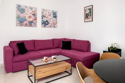a purple couch in a living room with a table at Avli Village House with Private Jacuzzi in Paradeísion