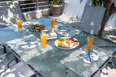 a table with plates of food and glasses of orange juice at Avli Village House with Private Jacuzzi in Paradeísion