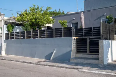 a fence on the side of a building at Avli Village House with Private Jacuzzi in Paradeísion