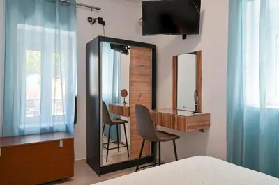 a bedroom with a desk and a mirror at Avli Village House with Private Jacuzzi in Paradeísion