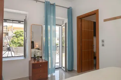a bedroom with a bed and a mirror and a door at Avli Village House with Private Jacuzzi in Paradeísion