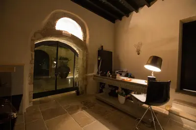 a room with a fireplace and a desk with a lamp at Allegory Boutique Hotel in Rhodes Town