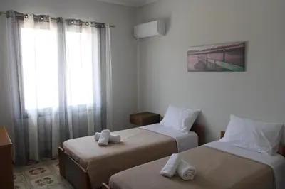 a hotel room with two beds and a window at Despinas Village House in Kalavárda