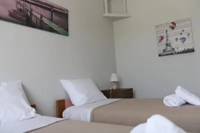 a bedroom with two beds and a picture on the wall at Despinas Village House in Kalavárda