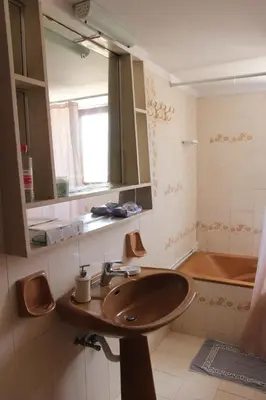 a bathroom with a sink and a mirror and a tub at Despinas Village House in Kalavárda