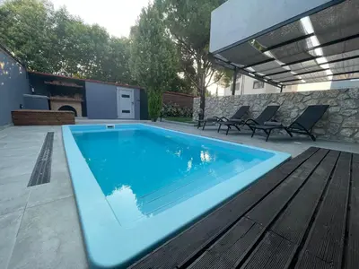 a swimming pool on a patio with a wooden deck at Casa del Emma in Koskinou in Koskinou