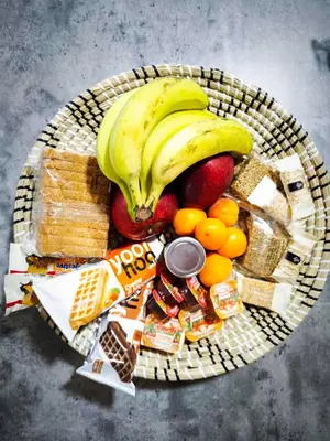 a basket of food with bananas oranges and other snacks at Mandilaria stone house in Afantou