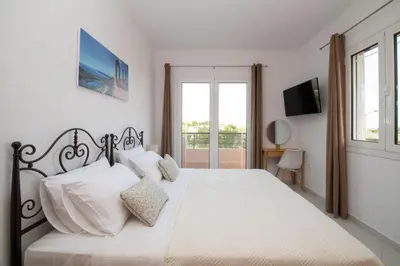 a bedroom with a large white bed with white pillows at Casa Serena in Lardos
