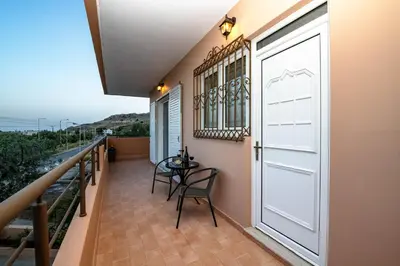 a balcony with a door and a table and chairs at Casa Serena in Lardos