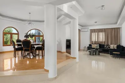 a dining room and living room with a table and chairs at Vento Estivo Mansion in Pastida