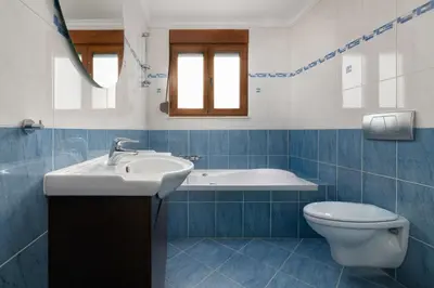 a blue and white bathroom with a sink and a toilet at Vento Estivo Mansion in Pastida