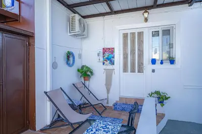 a room with chairs and a table and a door at Barbara's Apartments in Vrachonisída touArchangélou