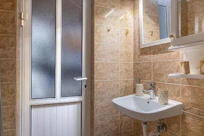 a bathroom with a sink and a mirror at Barbara's Apartments in Vrachonisída touArchangélou