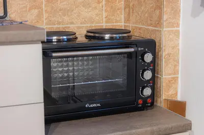 a black toaster oven sitting in a kitchen at Barbara's Apartments in Vrachonisída touArchangélou