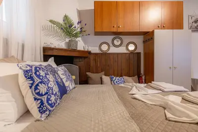 a bedroom with a large bed with blue and white pillows at Barbara's Apartments in Vrachonisída touArchangélou