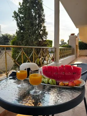 a tray of fruit on a table with two glasses of orange juice at Valsamo Suite in Ialyssos