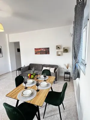 a living room with a wooden table and chairs at Valsamo Suite in Ialyssos