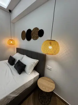 a bedroom with a bed and two lights and a table at Valsamo Suite in Ialyssos